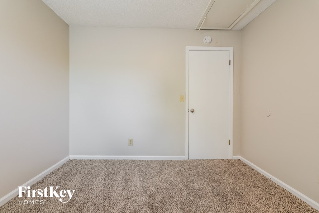 a bedroom with a carpeted floor and a white door