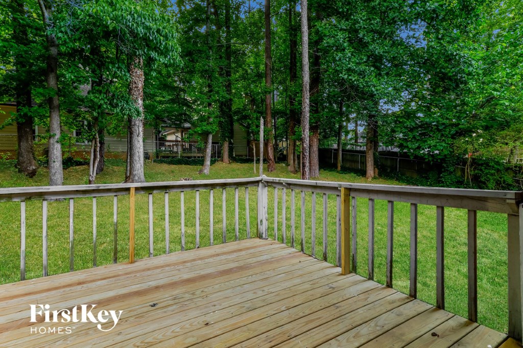 a wooden deck overlooking a yard with trees
