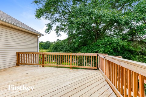 a backyard deck with trees and a house