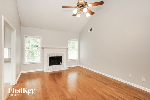 a living room with a fireplace and a ceiling fan
