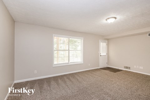 a spacious living room with carpet and a large window