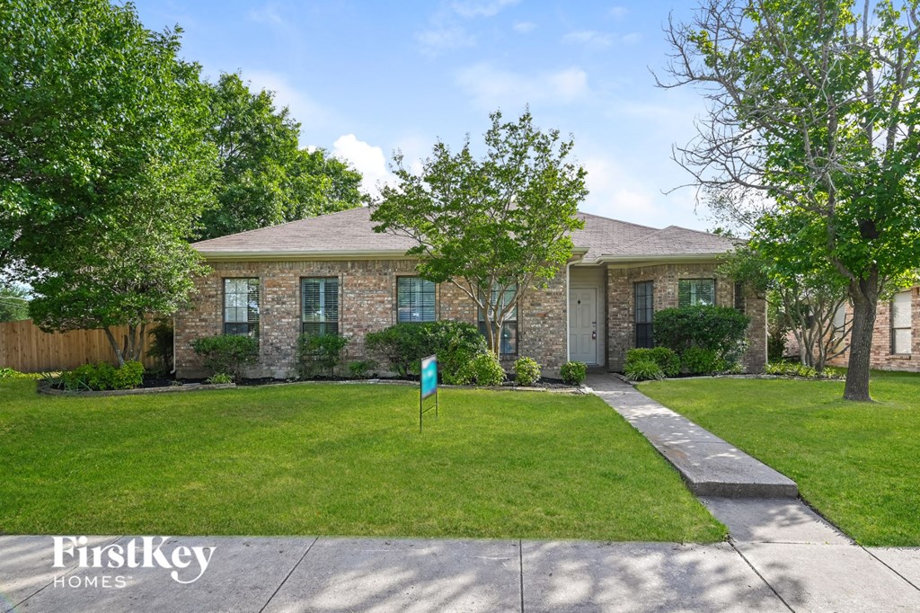 a home with a lawn and a blue flag in front of it