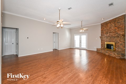the living room with a fireplace and wood flooring and a ceiling fan
