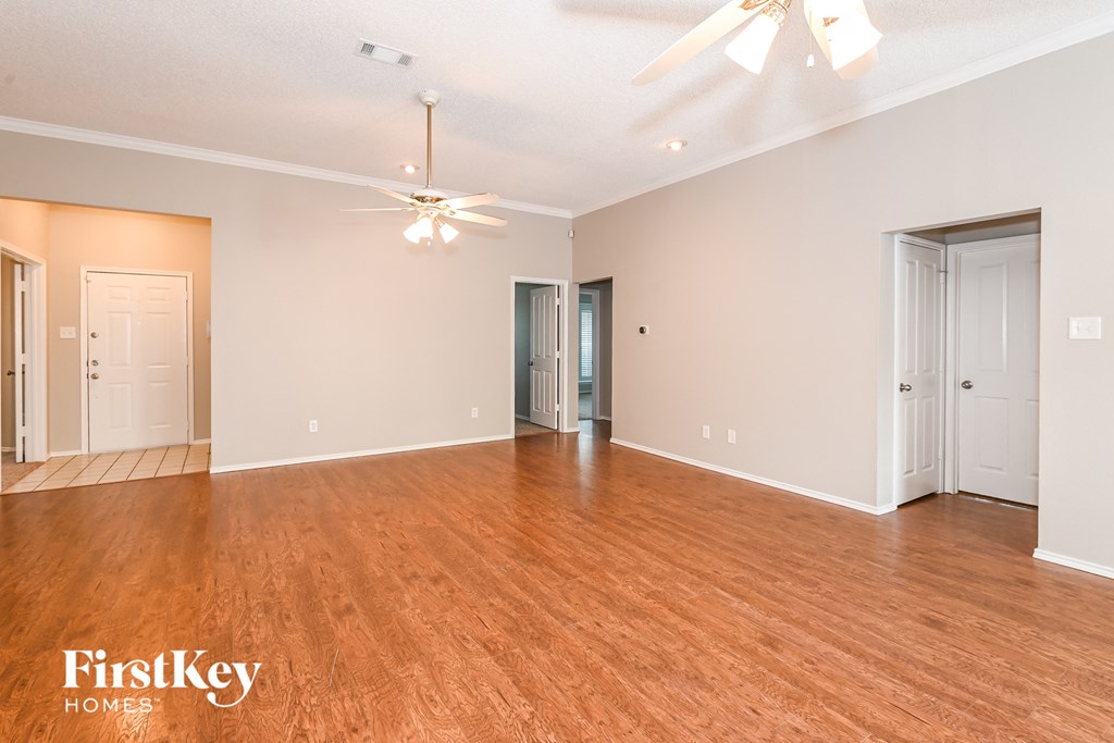 a living room with a wood floor and a ceiling fan