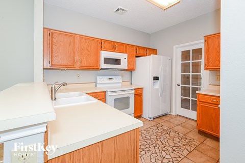 a kitchen with wooden cabinets and white appliances and a refrigerator