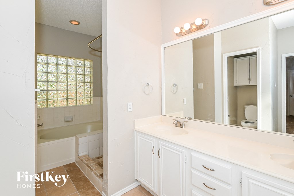 a bathroom with a large mirror and a sink and a tub