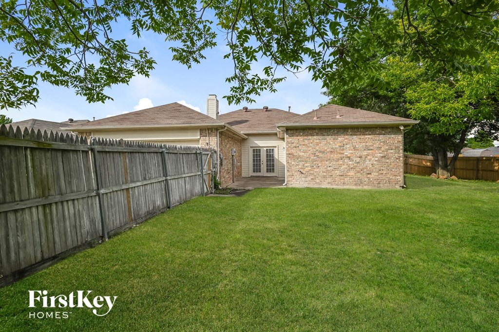 a backyard with a fence and a house