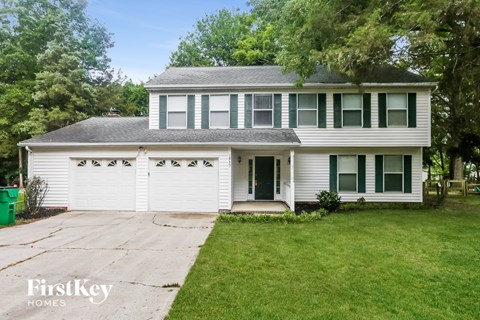 a white house with a driveway and a white garage door