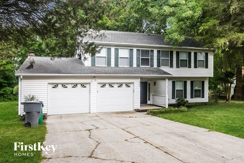 a white house with a white garage door and a driveway
