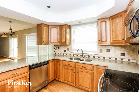a kitchen with wooden cabinets and stainless steel appliances and a sink