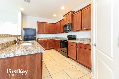 A kitchen with wooden cabinets and a granite countertop.
