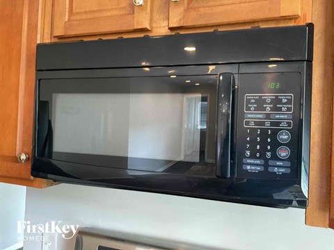 a microwave oven in a kitchen with wooden cabinets