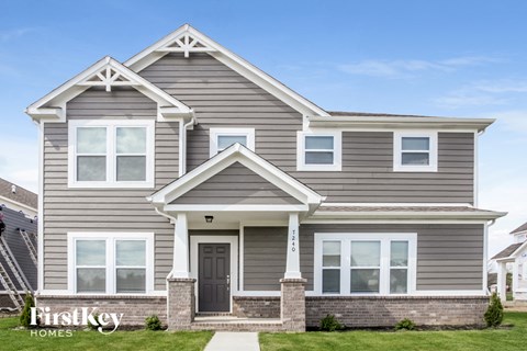 a gray house with white trim and a black door