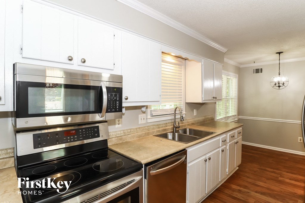 A kitchen with a stove top oven and microwave.