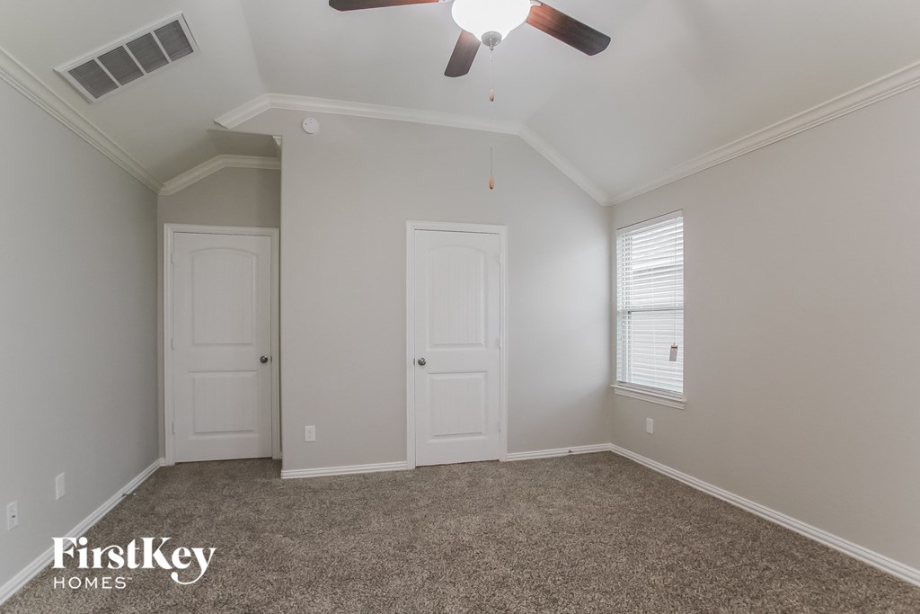 a bedroom with white doors and a ceiling fan