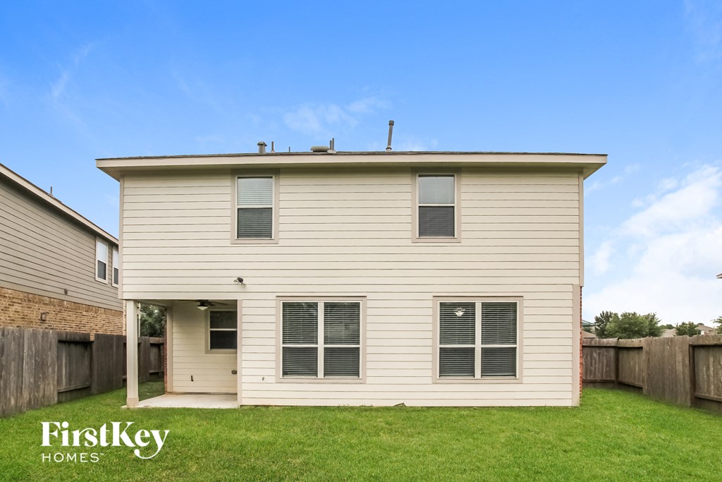 a white house with white siding and a backyard with grass