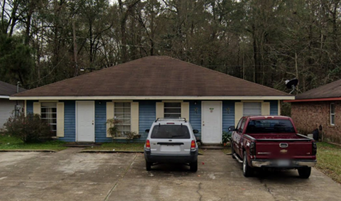 a house with two cars parked in front of it