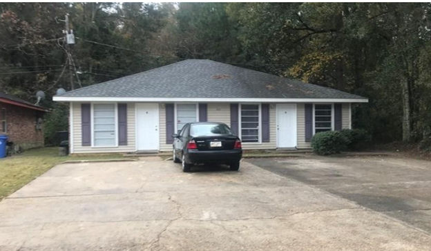 a car parked in front of a white house