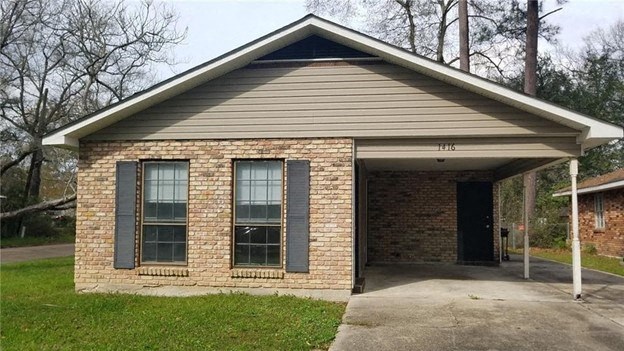 a brick house with a front porch and a driveway