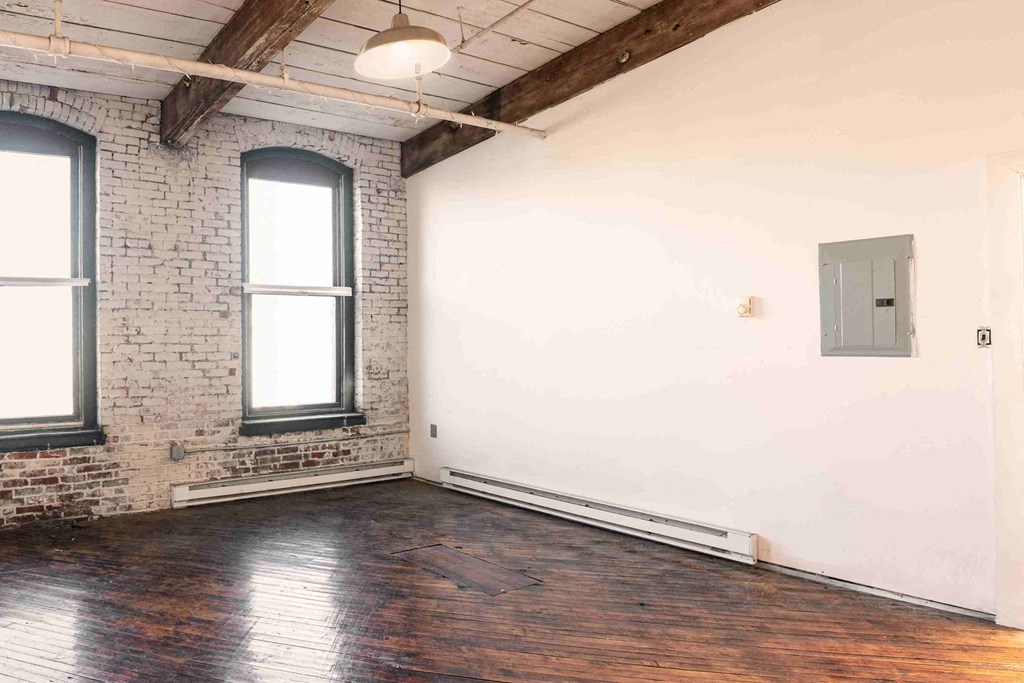 an empty room with exposed brick and a window