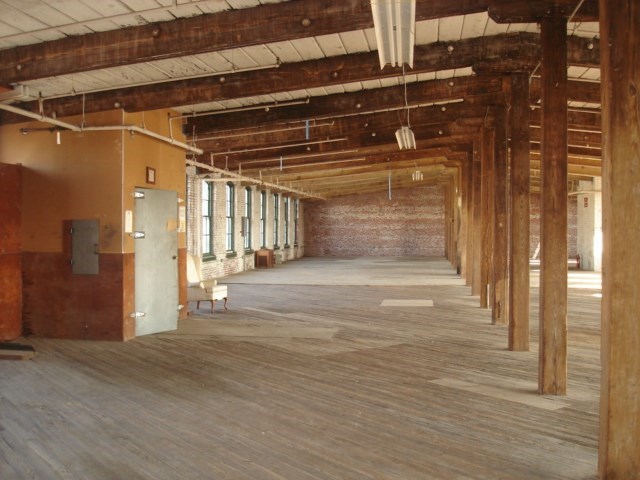 the inside of a building with wooden beams and a wood floor