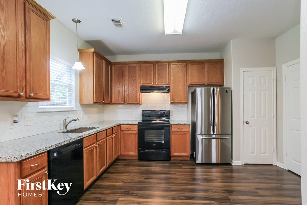 a kitchen with wooden cabinets and a stainless steel refrigerator
