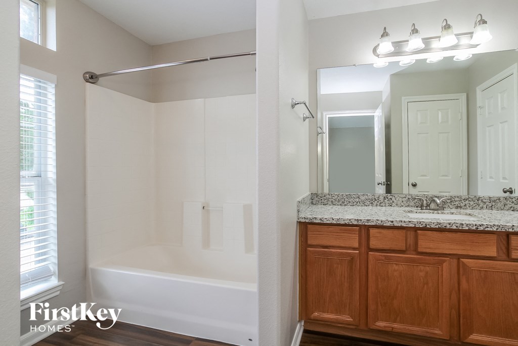 a bathroom with a shower and a sink and a mirror