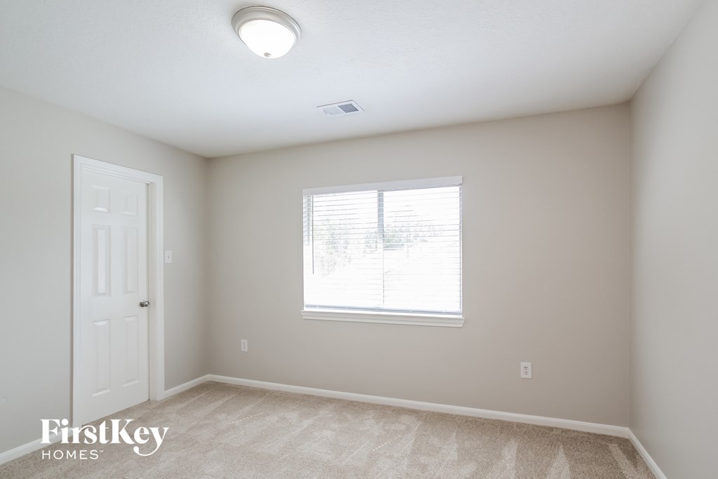 a bedroom with a window and a white door