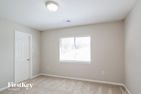a bedroom with a window and a white door