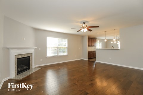 A spacious living room with a fireplace and wood flooring.