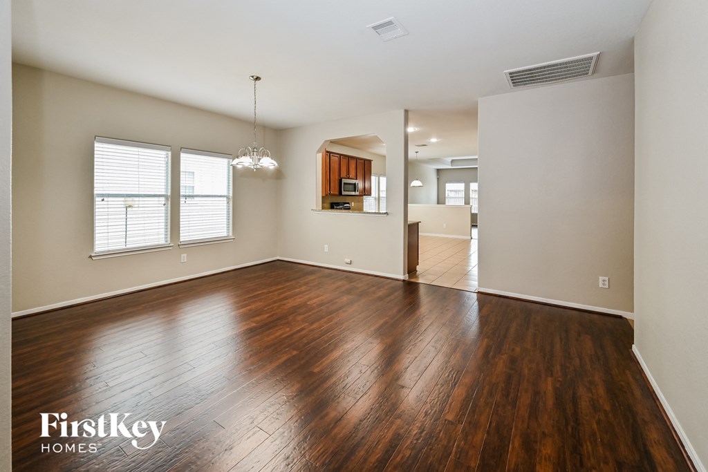 A room with wooden floors and a chandelier.