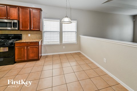 A kitchen with brown cabinets and a black stove top oven.