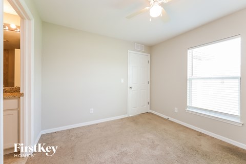 a bedroom with a carpeted floor and a large window
