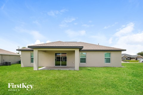 the view of the exterior of a home with green grass and a blue sky