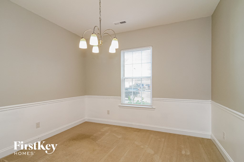 a dining room with white walls and a window