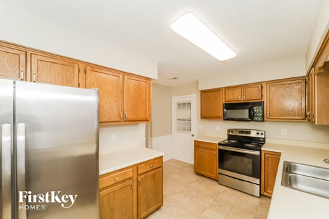 A kitchen with wooden cabinets and a stainless steel refrigerator.