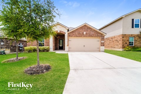 an empty driveway in front of a house with a tree