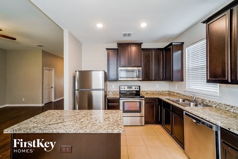 a kitchen with granite counter tops and stainless steel appliances