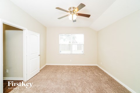 a bedroom with a ceiling fan and a closet