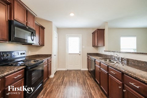 a kitchen with wooden floors and stainless steel appliances