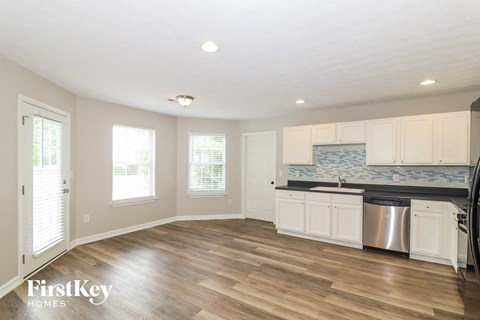 a kitchen with white cabinets and stainless steel appliances and a wooden floor