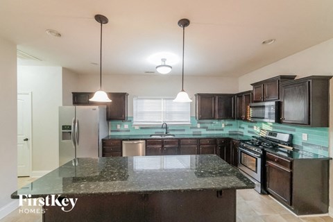 a kitchen with dark wood cabinets and granite counter tops