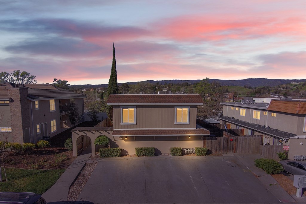 a view of a house with a sunset in the background