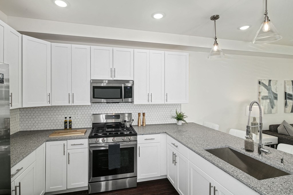a kitchen with white cabinets and stainless steel appliances
