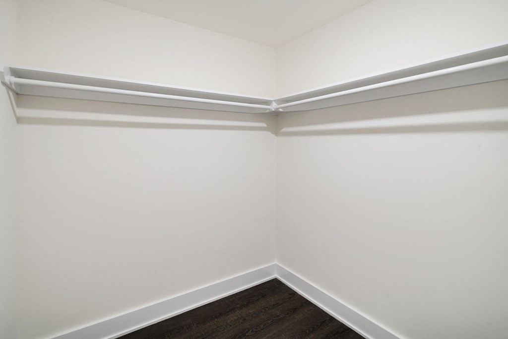 a corner of a room with white walls and a wooden floor