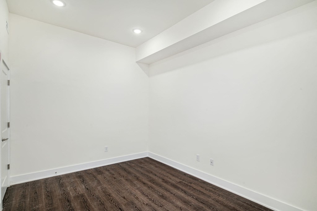 a living room with white walls and wood floors