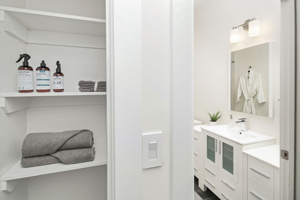 a bathroom with white cabinets and a sink and a mirror