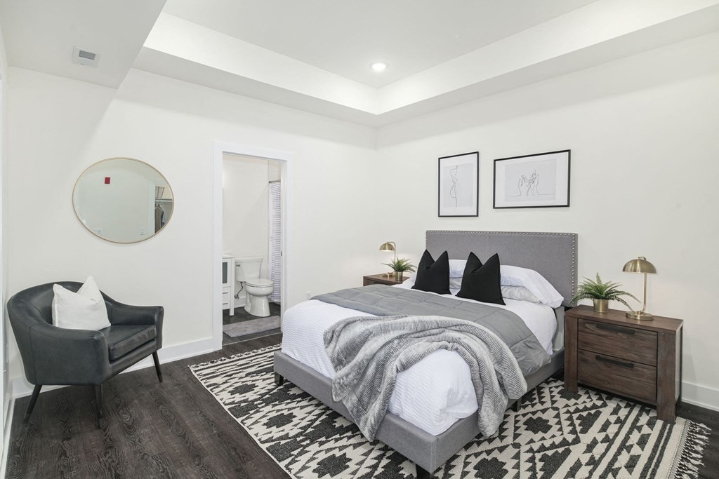 a bedroom with a large bed and a mirror