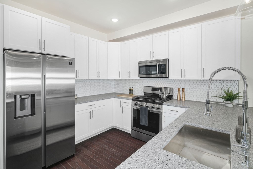 a kitchen with white cabinets and stainless steel appliances