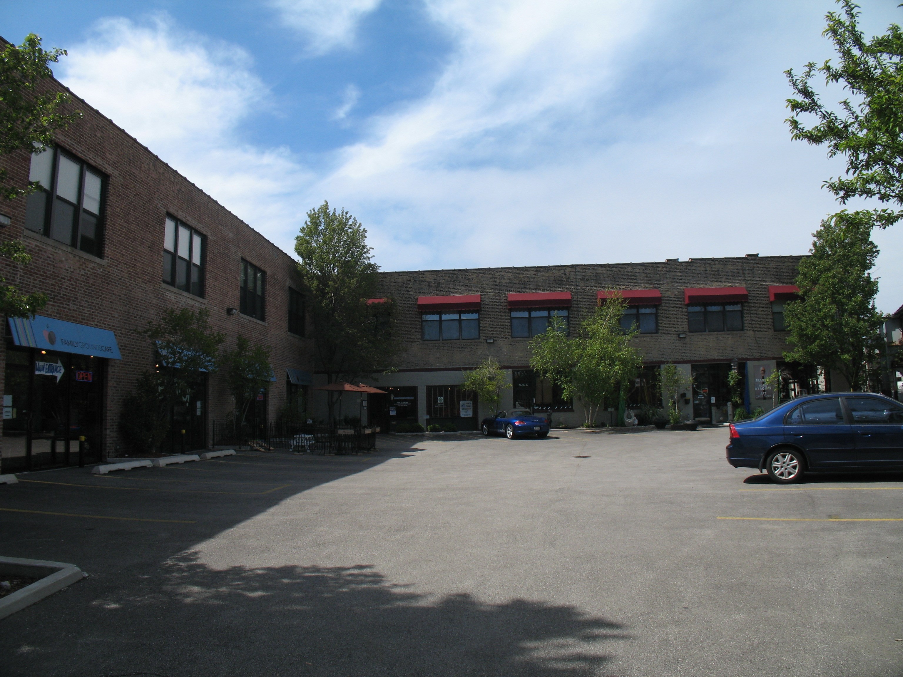 an empty parking lot in front of a brick building